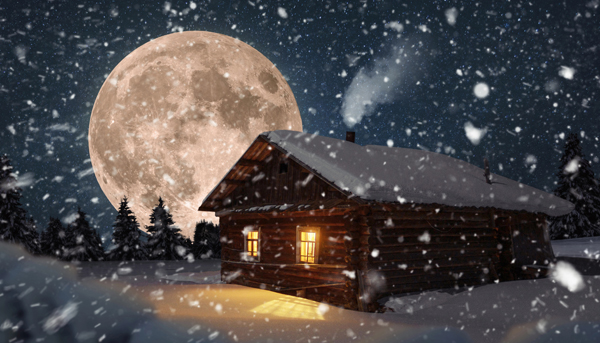 Eine junge erkältete Frau sitzt in einem weihnachtlich geschmückten Zimmer auf einer Couch