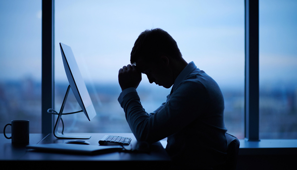 Ein Mann sitzt im Dunkeln im Büro