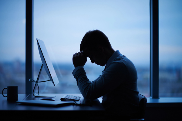Ein Mann sitzt im Dunkeln im Büro