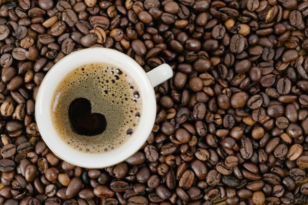 Eine Tasse Kaffee und viele Kaffeebohnen